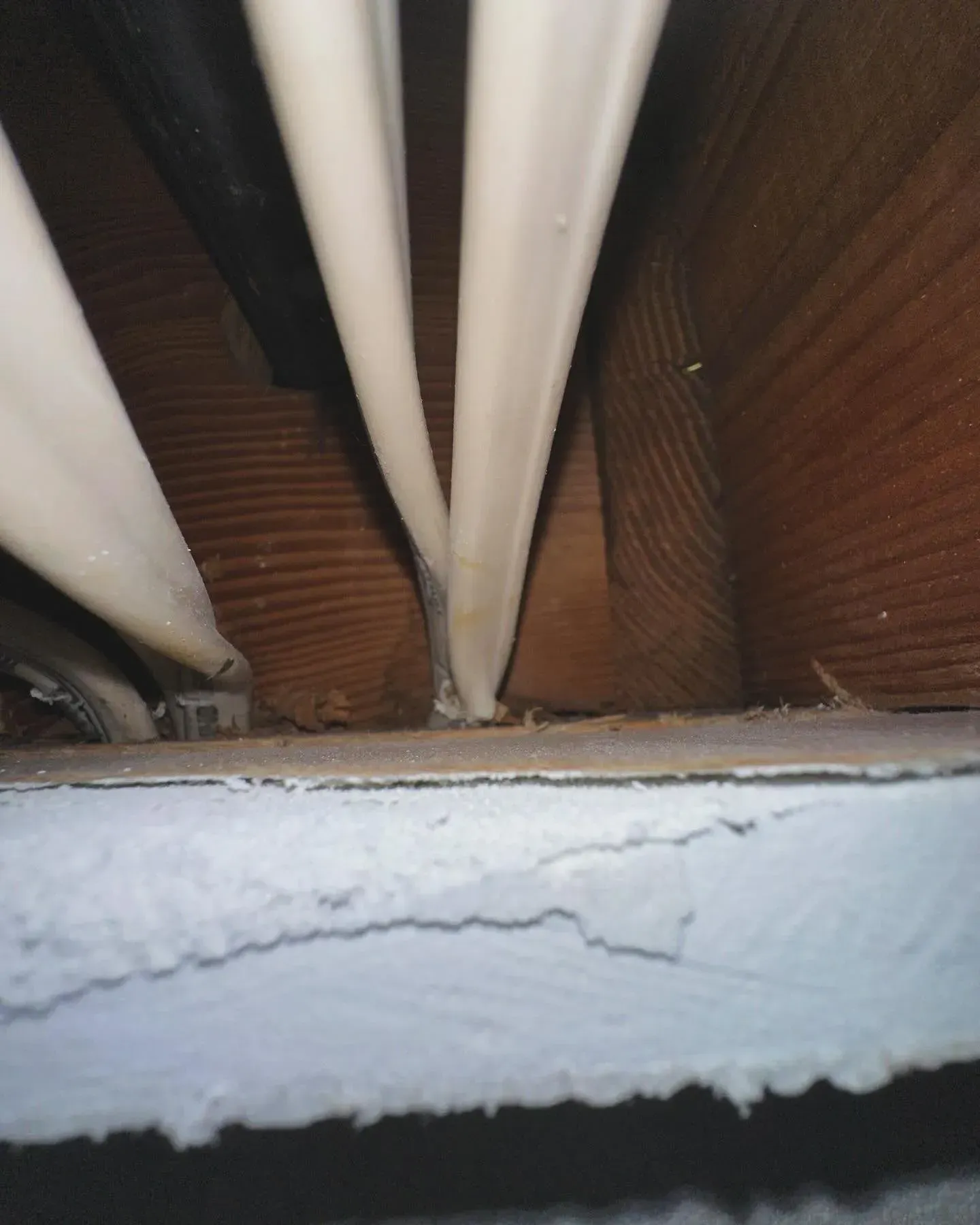 A bunch of white pipes are hanging from the ceiling of a building.