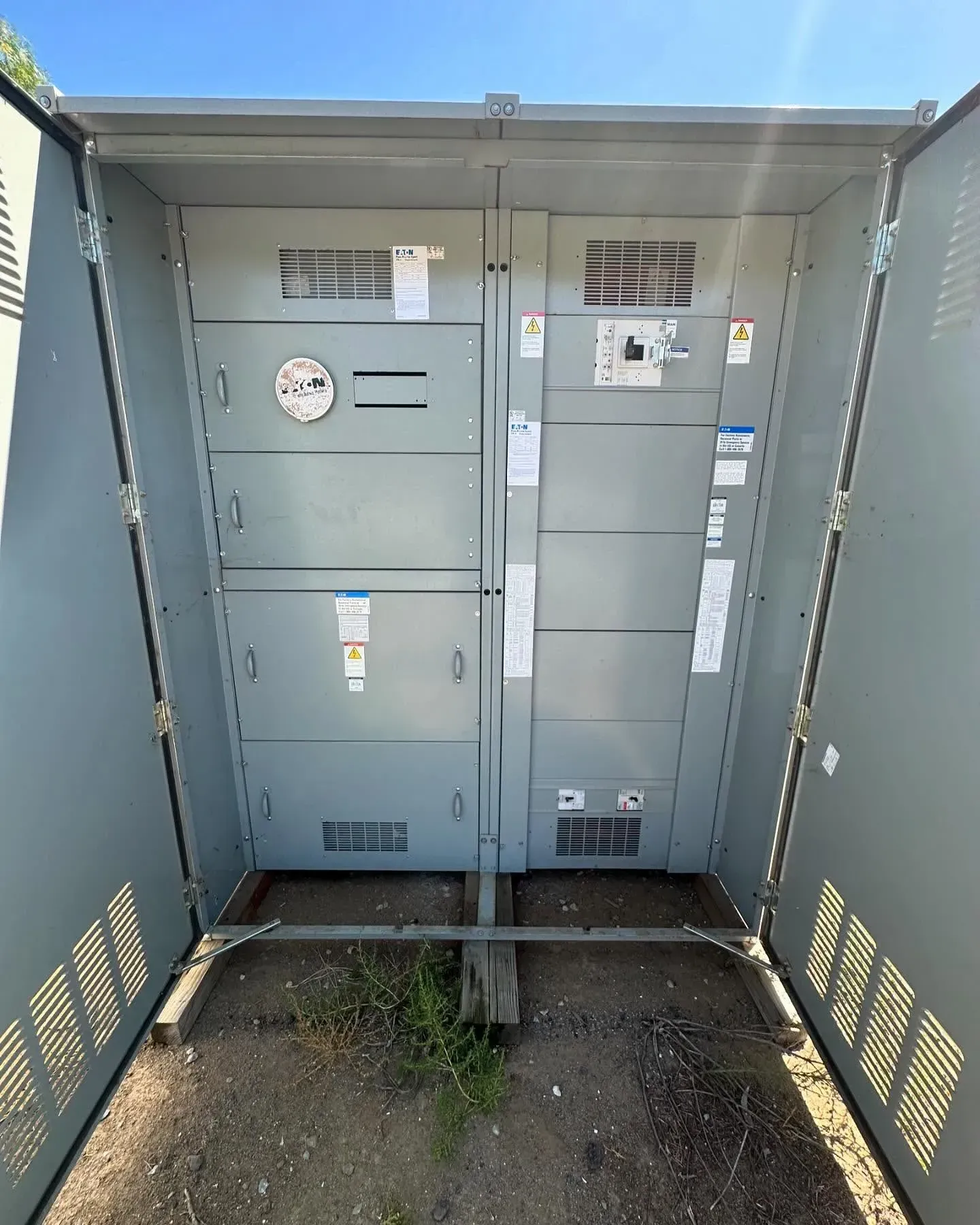 A large metal electrical box with a blue sky in the background