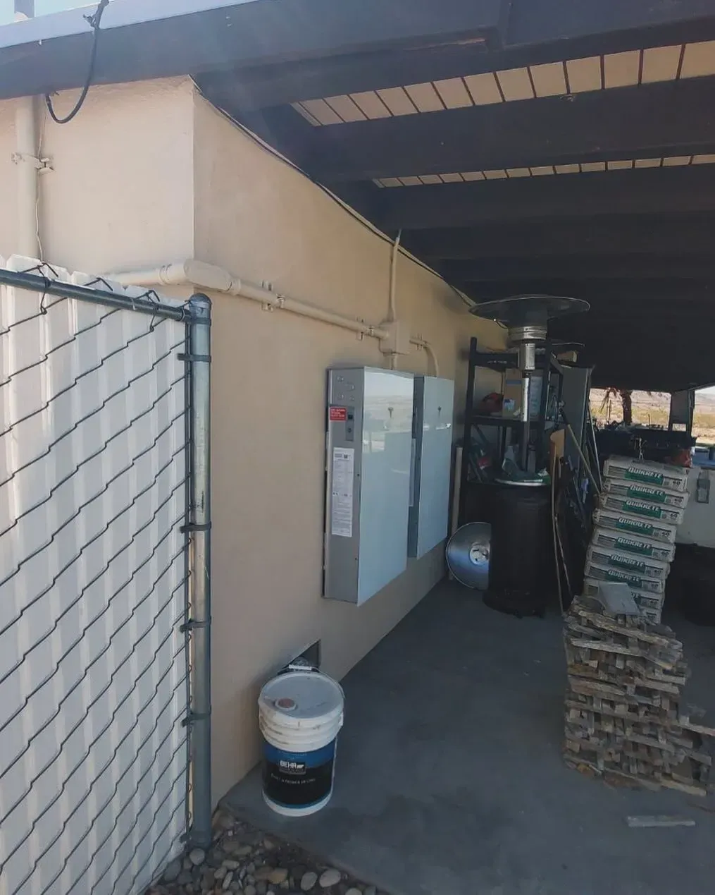 A building with a fence and a few boxes on the wall