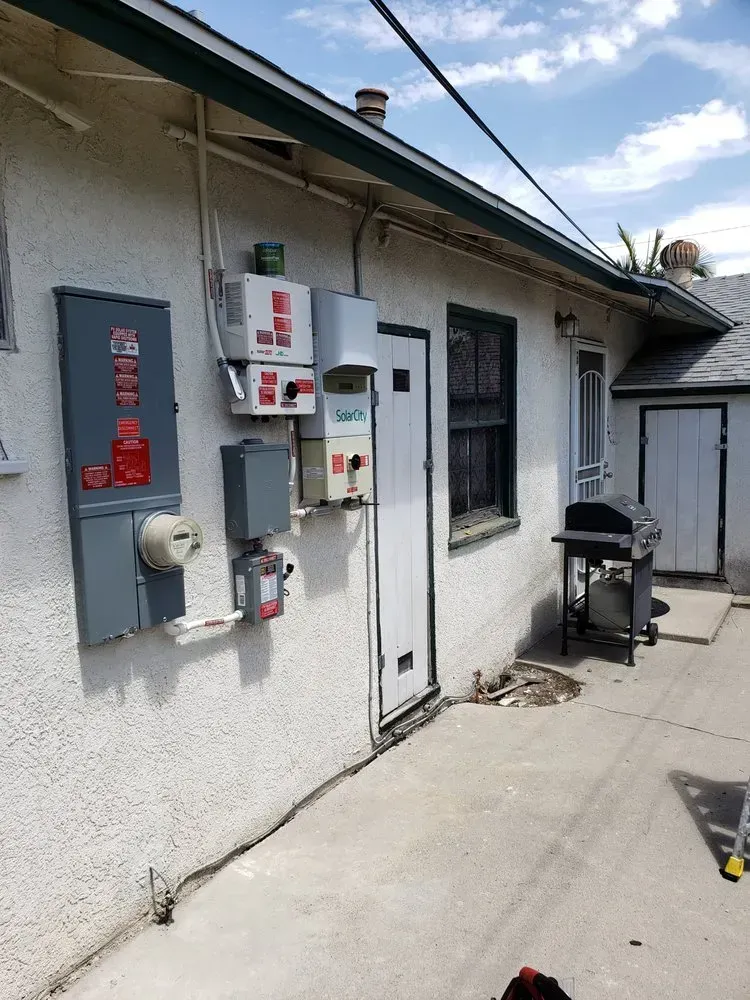 A white building with a door and a grill on the side of it.