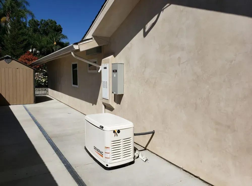 A generator is sitting on the side of a house.