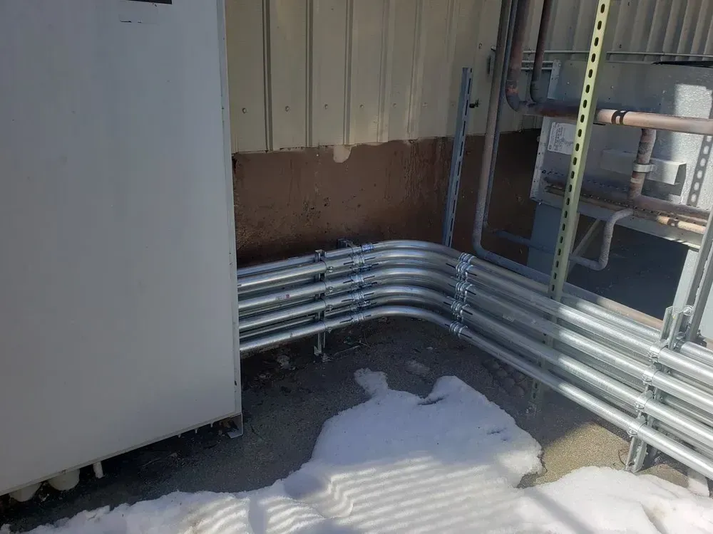 A bunch of metal pipes are connected to a building.