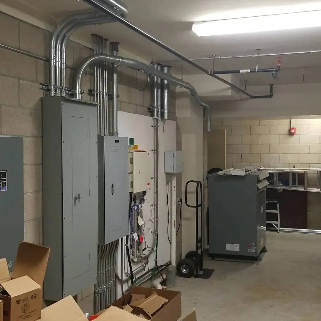 A room with a lot of electrical equipment and boxes on the floor