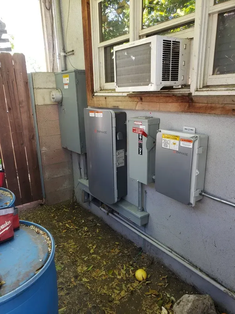 A house with a lot of electrical equipment on the side of it.