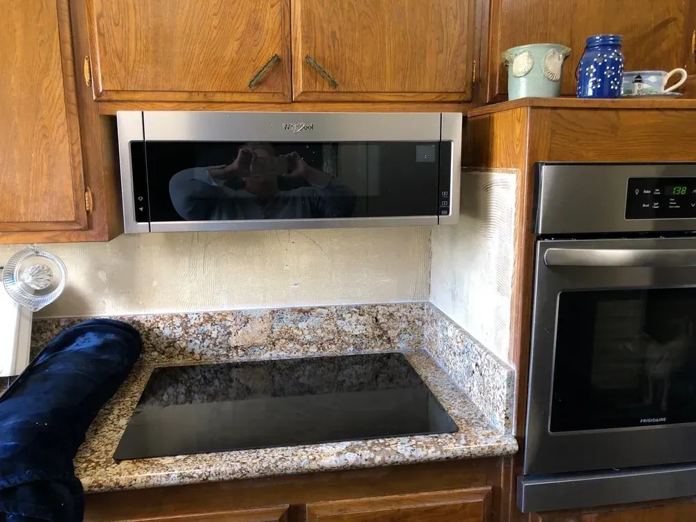A kitchen with a microwave oven and a stove top oven.