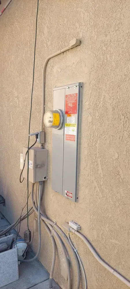 There is a electrical box on the side of a building.
