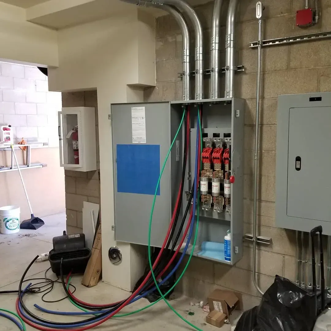 A box with a blue sticker on it has a lot of wires coming out of it