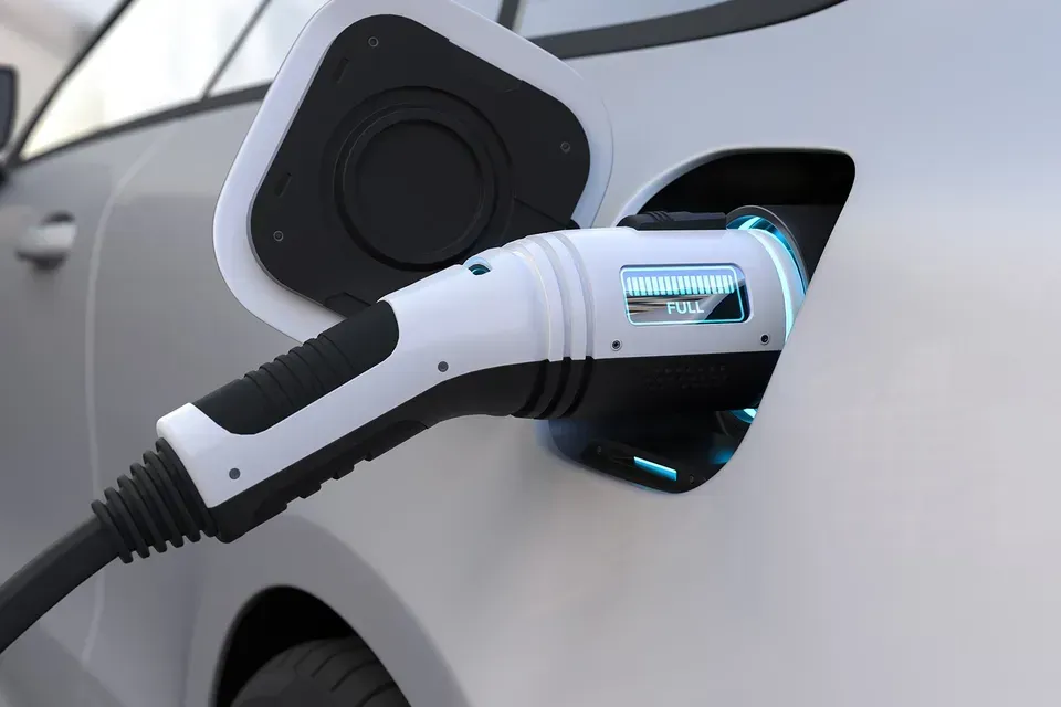 An electric car is being charged by a charging station.