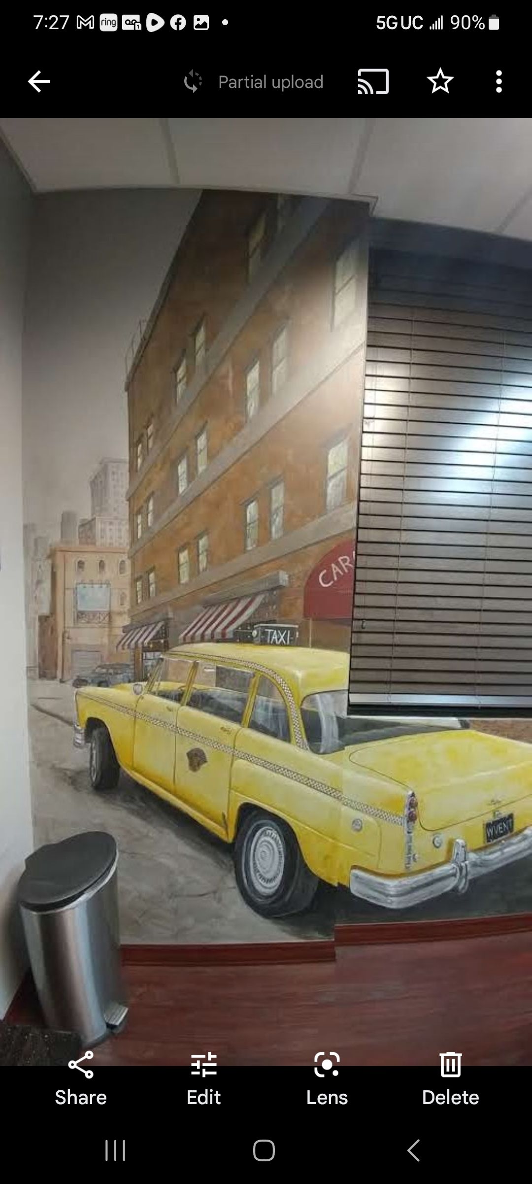 A yellow taxi cab is parked in front of a building on a city street.