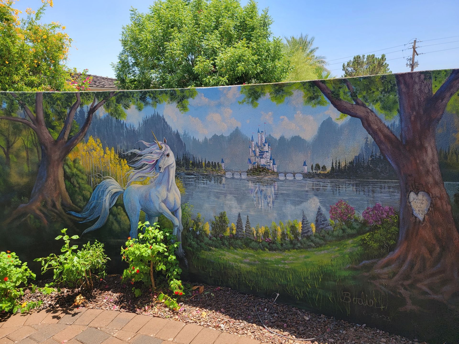 There is a painting of a unicorn on the side of a fence.