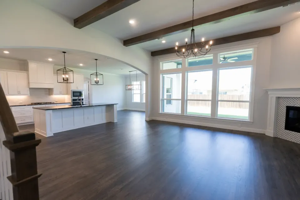 A large empty living room with hardwood floors and a fireplace.