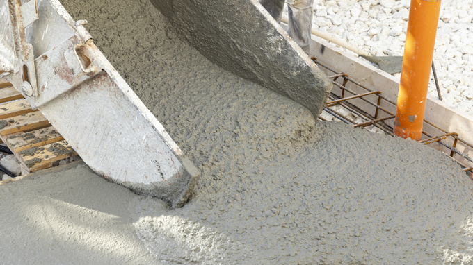 Concrete pouring from a chute onto rebar at a construction site