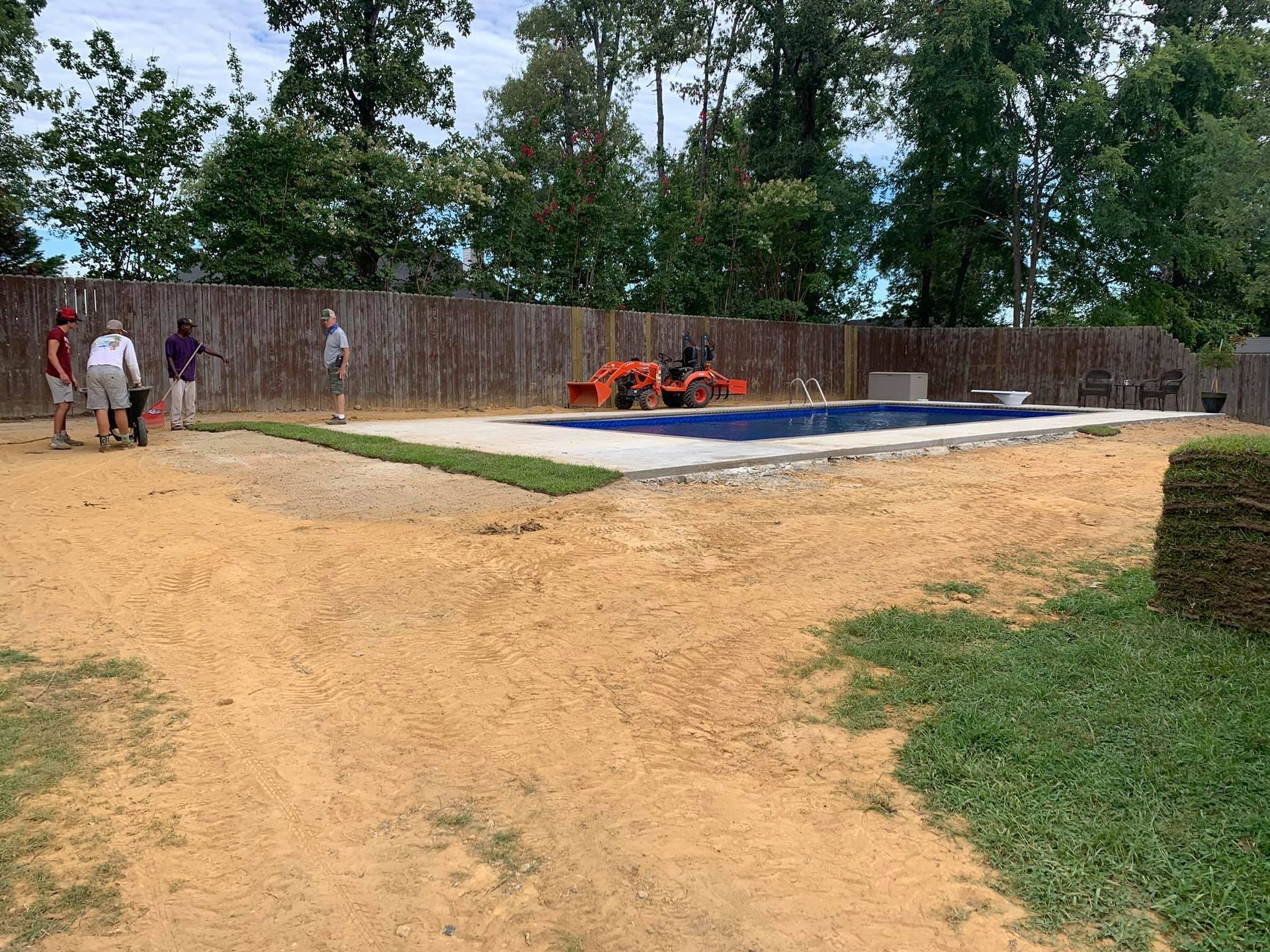 A group of people are standing in front of a swimming pool.