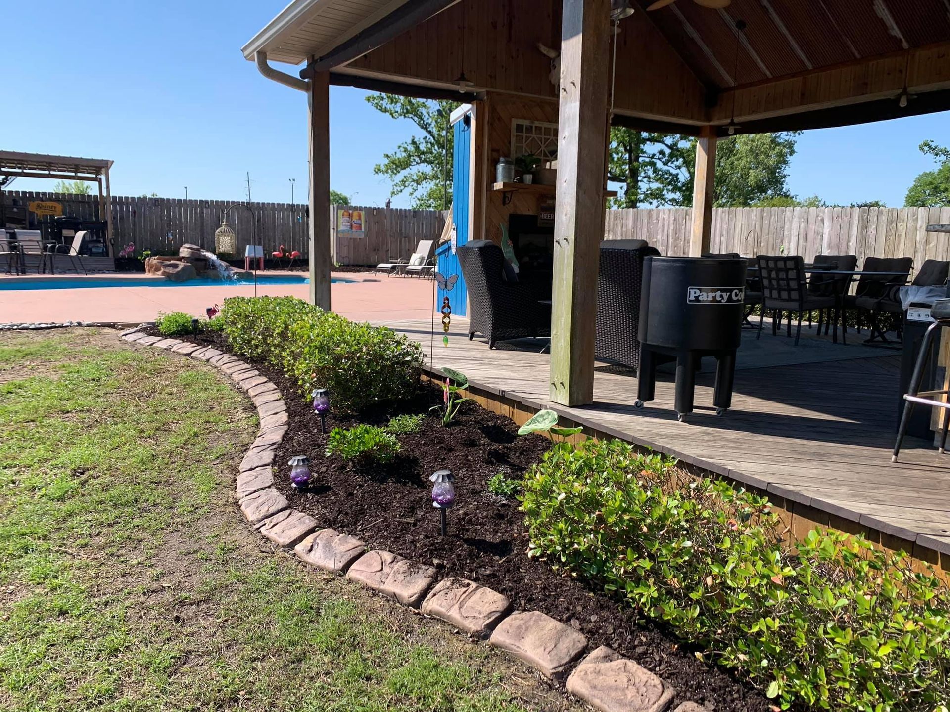 A patio area with a gazebo and a swimming pool in the background.