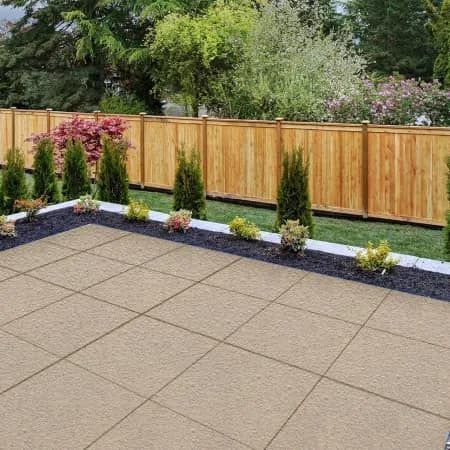 A backyard with a wooden fence and a patio.