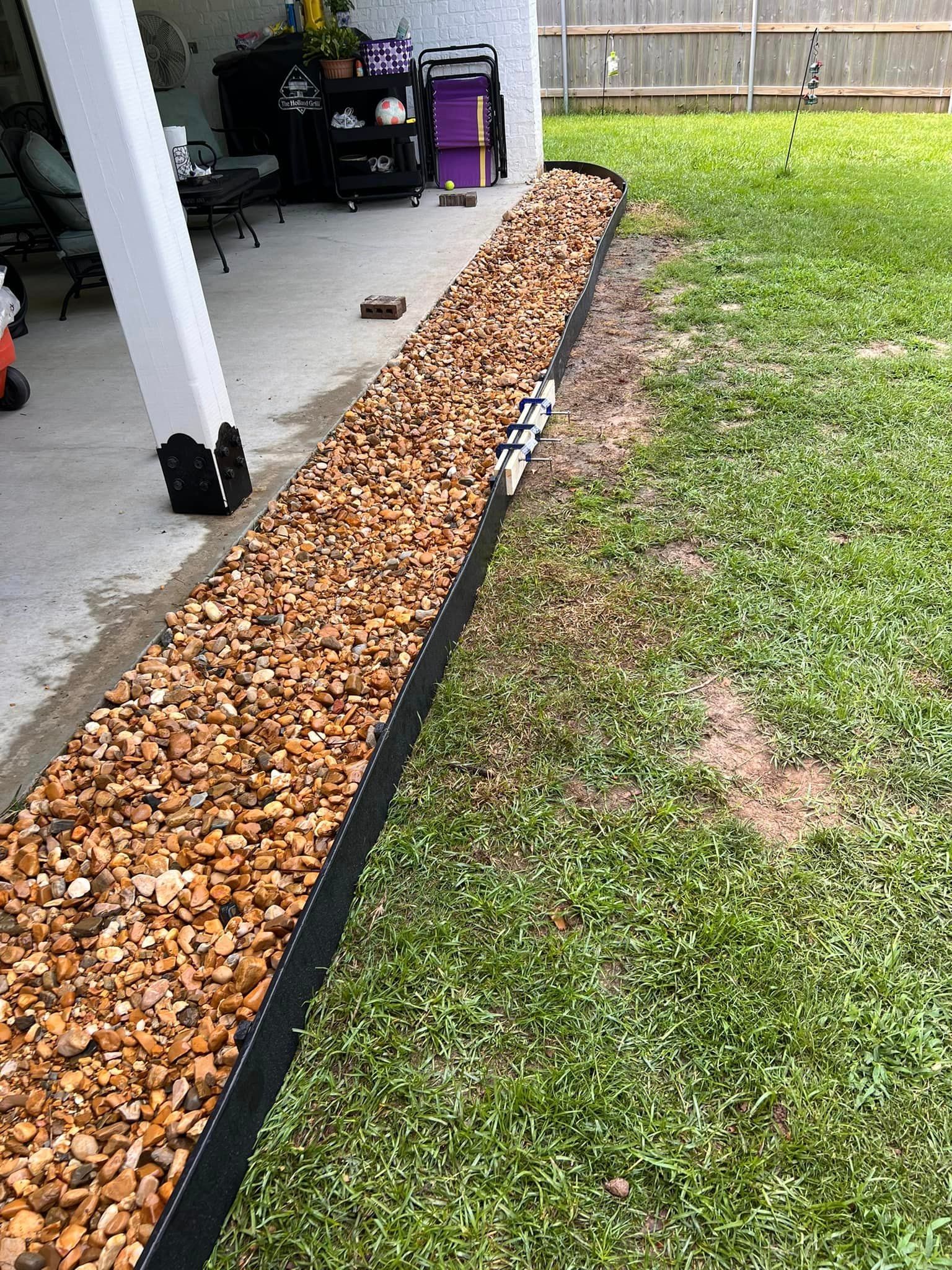 A lawn with a black edging and gravel.