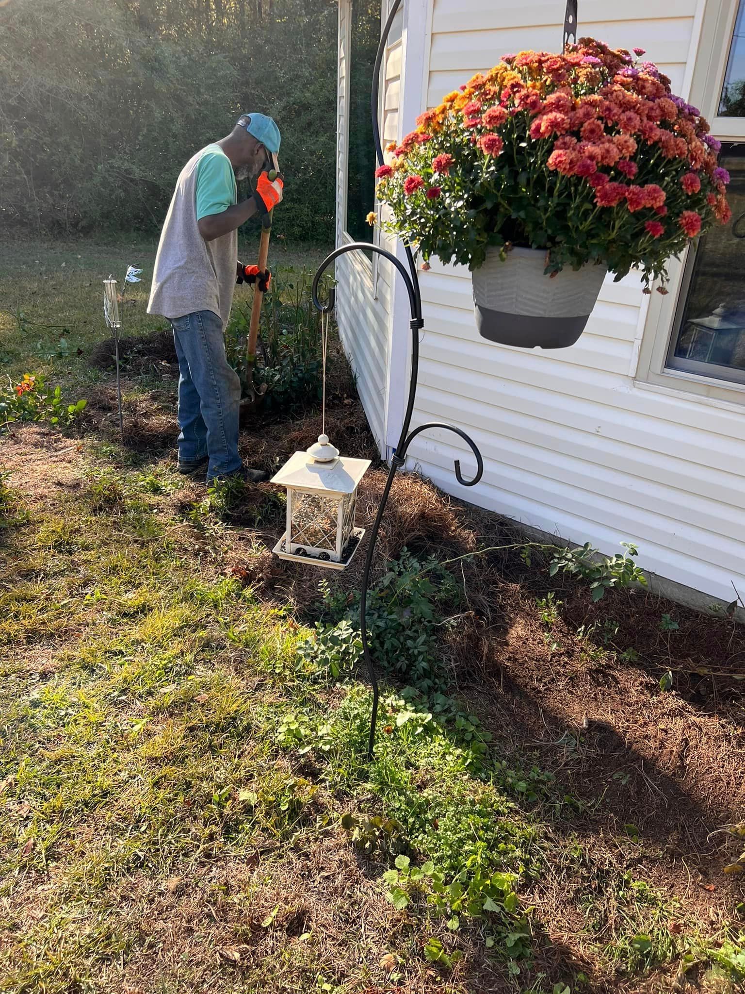 A man is standing in the grass in front of a house.