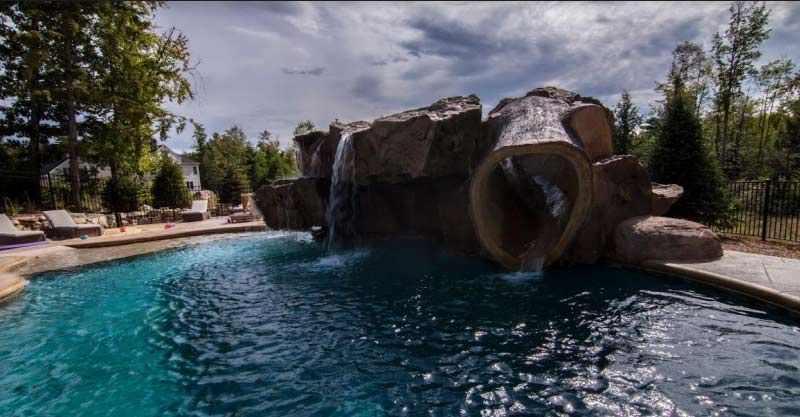 A large swimming pool with a waterfall in the middle of it.