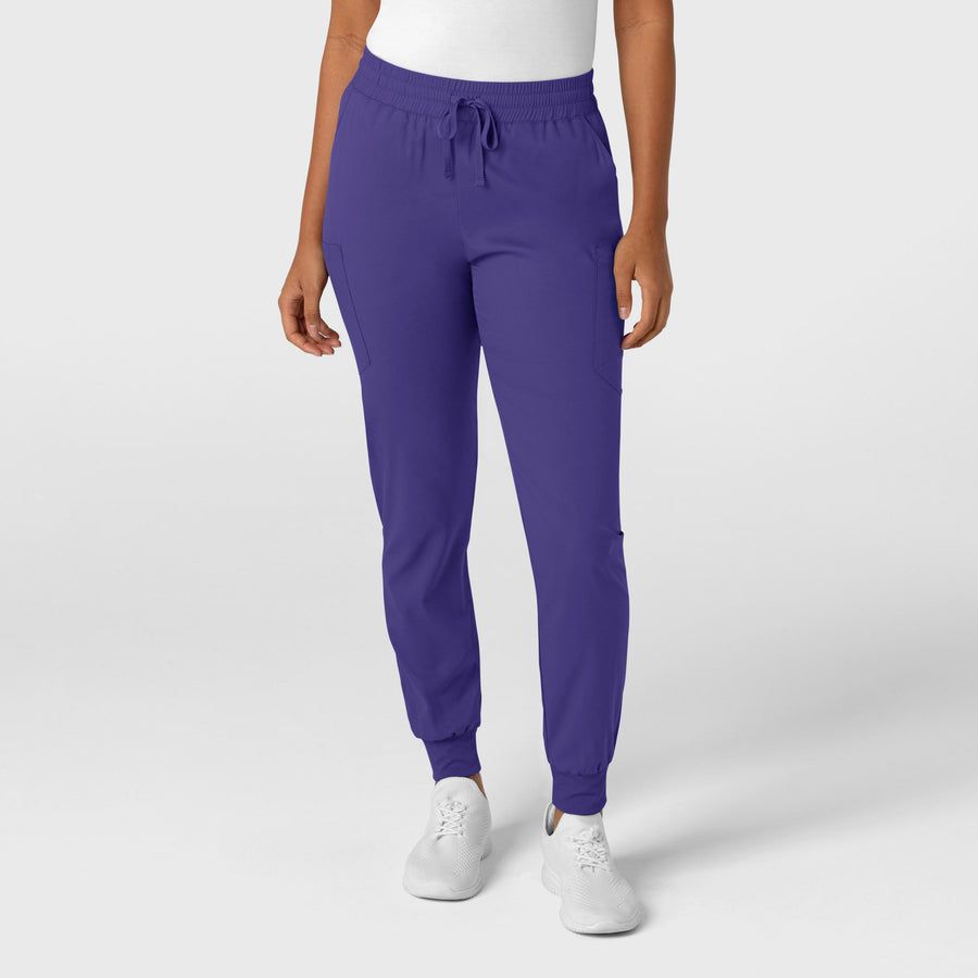 Woman wearing purple jogger pants with white sneakers.