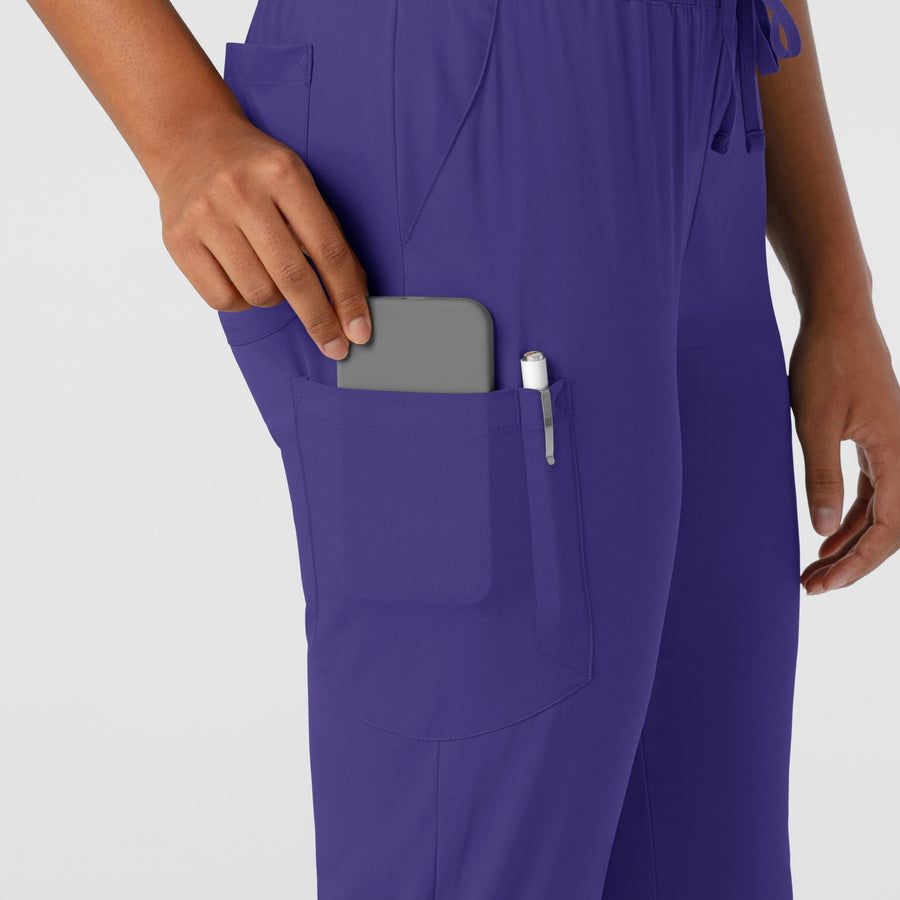 Person in purple pants with phone and pen in pockets.