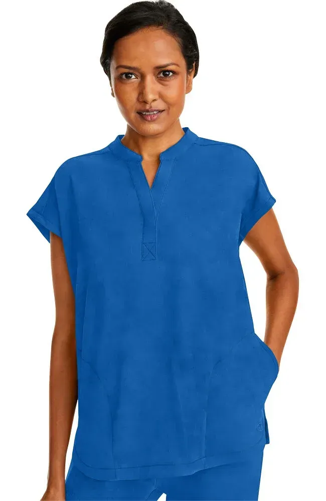 Woman wearing a short-sleeved blue medical scrub top with a notched neckline and front pockets.