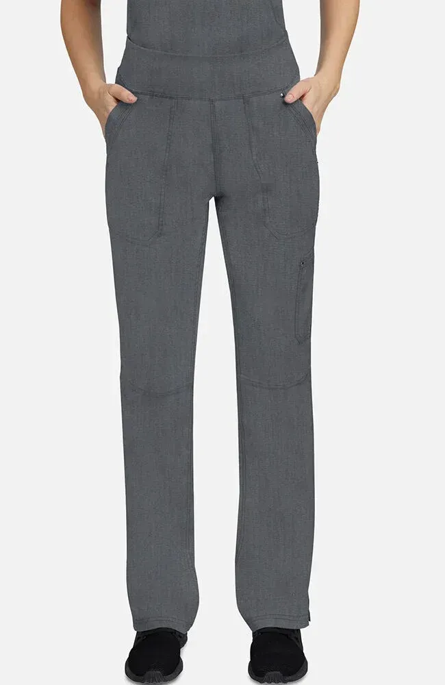 Woman wearing gray scrub pants with pockets, hands in pockets.