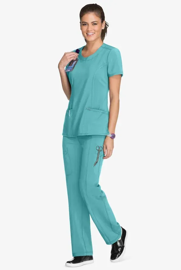 Woman in teal scrubs, stethoscope around neck, smiling.