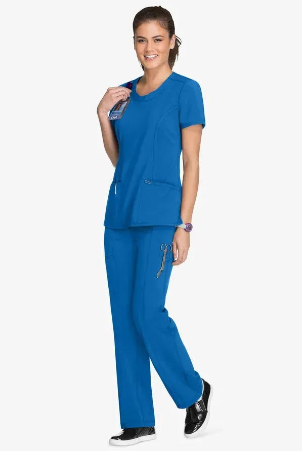 Woman wearing blue scrubs, smiling, holding a stethoscope, and posing.