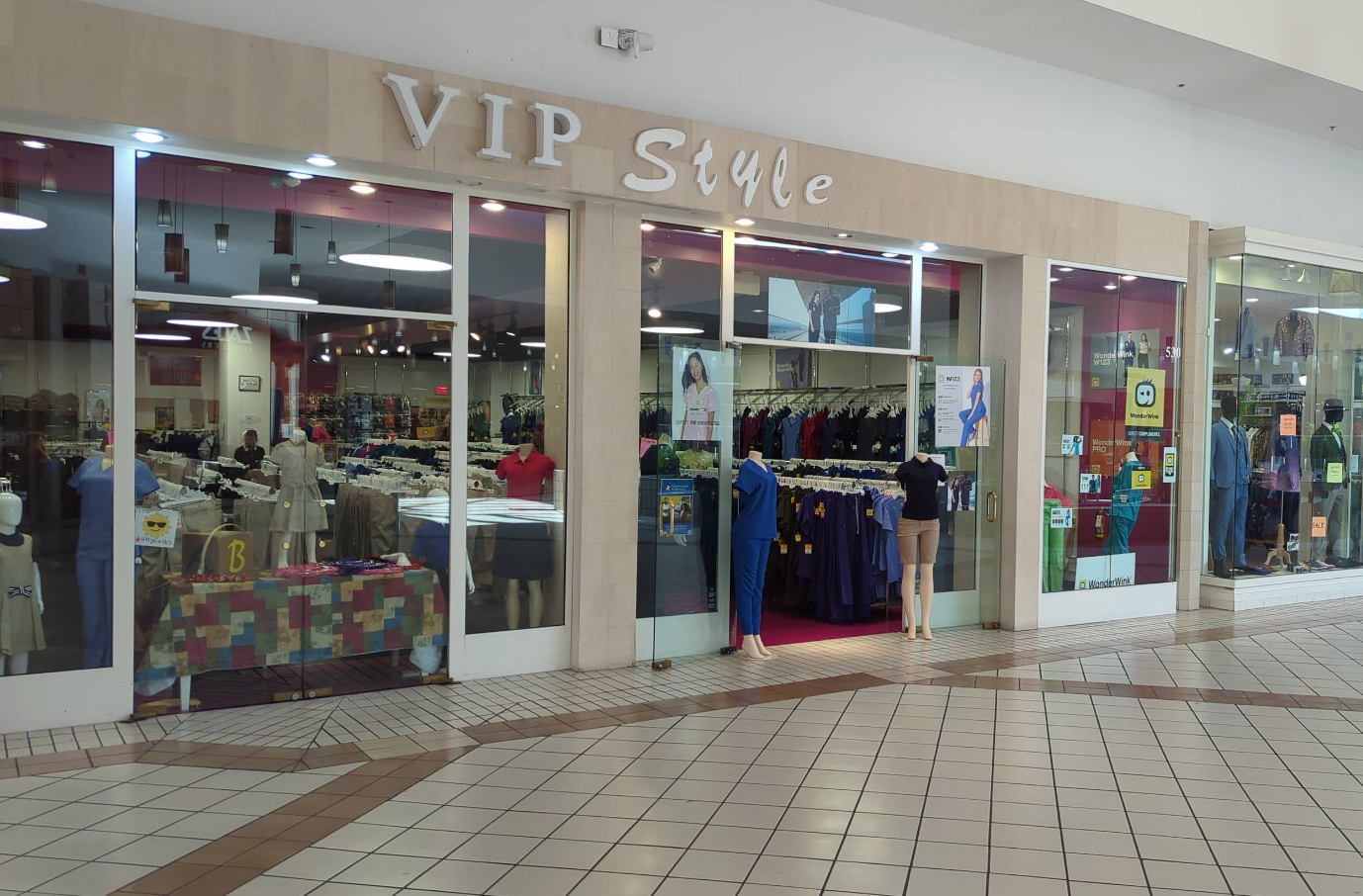 A clothing store called VIP Style in a mall, displaying clothes and mannequins.
