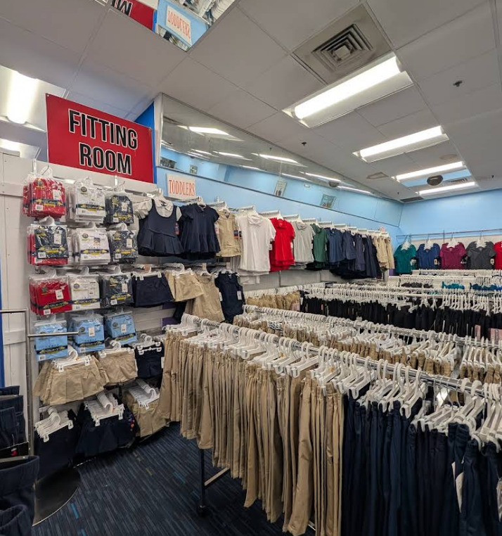 Clothing store interior with racks of school uniforms.