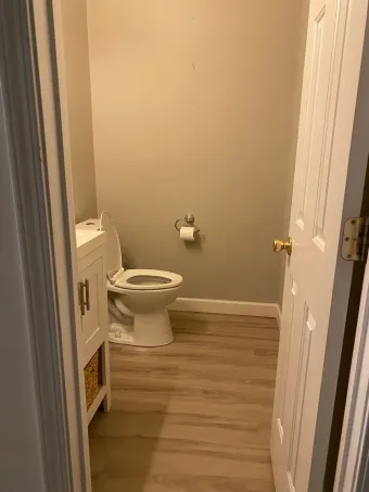 A bathroom with a toilet , sink , and door.