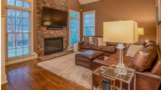 A living room with a couch , fireplace and television.