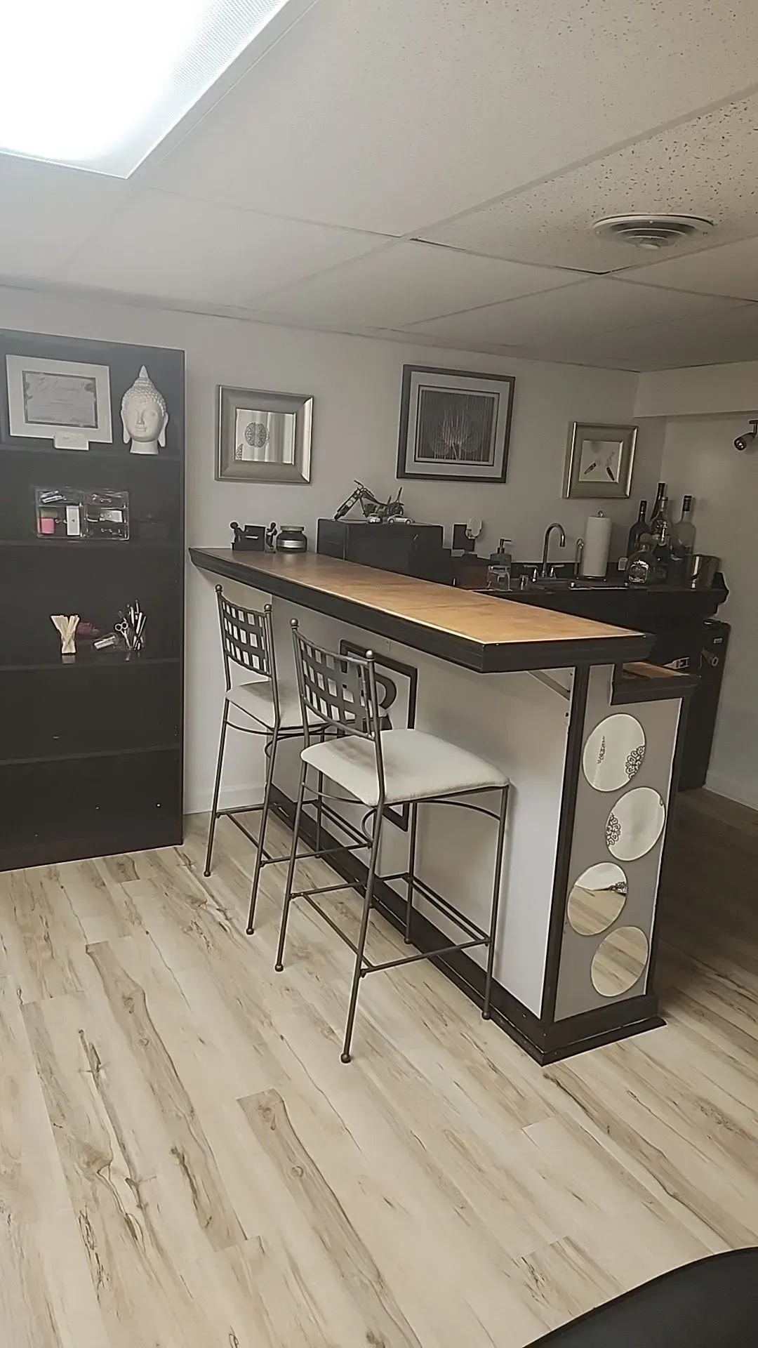 A room with a bar and stools in it.