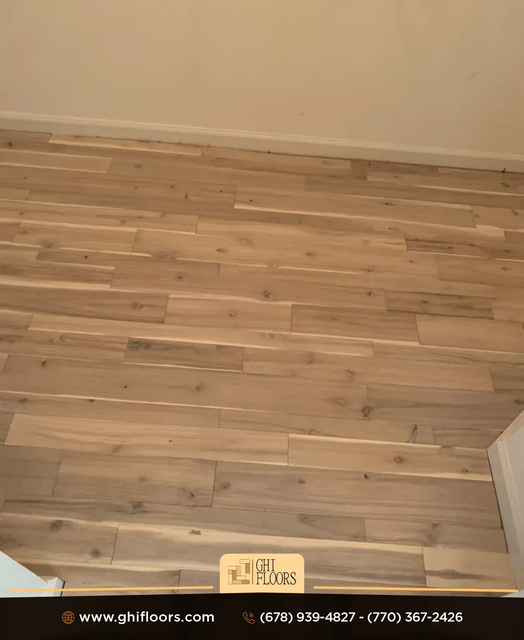 A wooden floor in a room with a white wall.