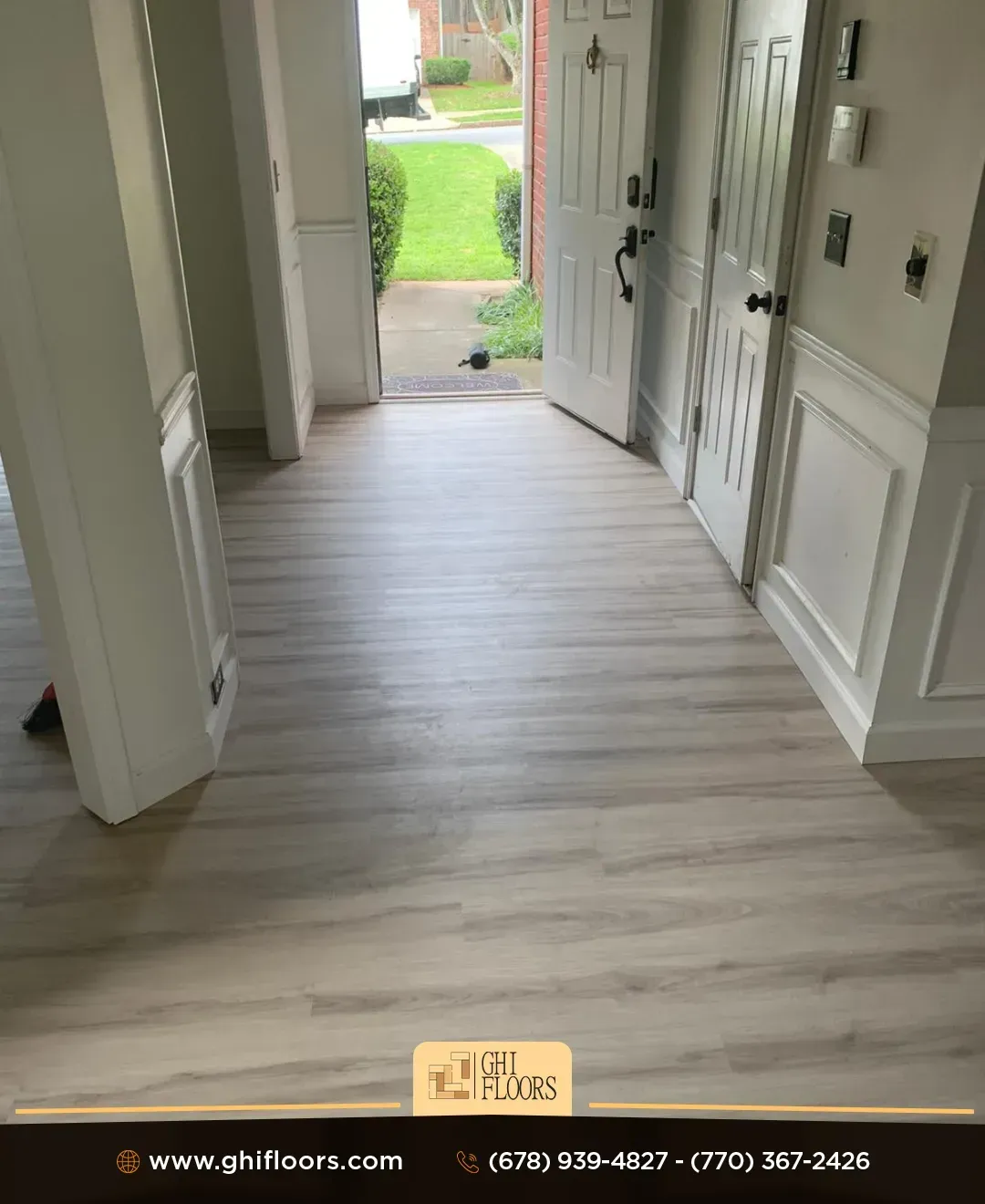 A hallway in a house with a wooden floor and white trim.