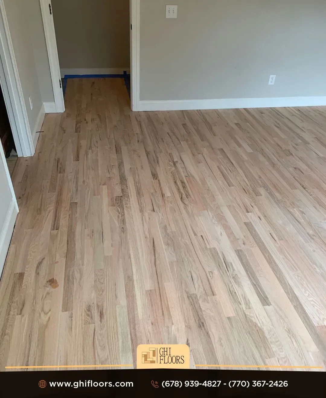 A living room with a wooden floor and a gray wall.
