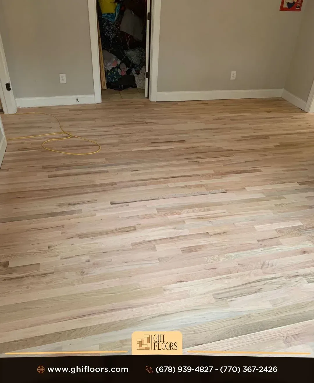 A room with a wooden floor and a door leading to a closet.