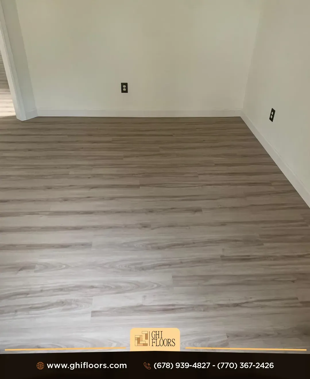 Room with light brown wood-look flooring and white walls. Two electrical outlets visible.