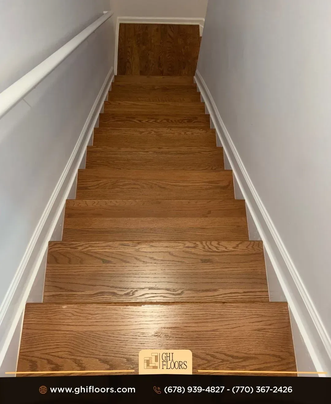 A set of wooden stairs leading up to a white wall.
