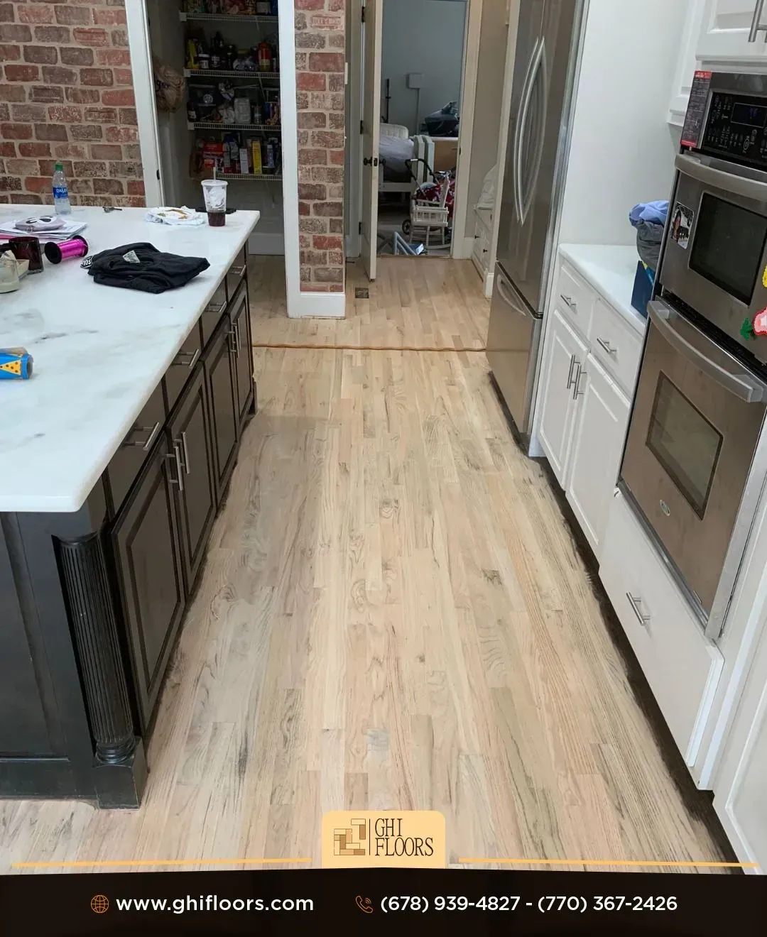 A kitchen with a wooden floor and stainless steel appliances.