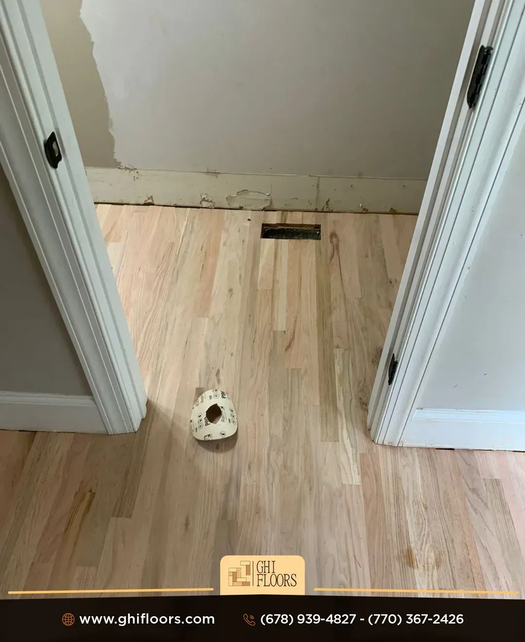 A wooden floor is being installed in a room with two doors.