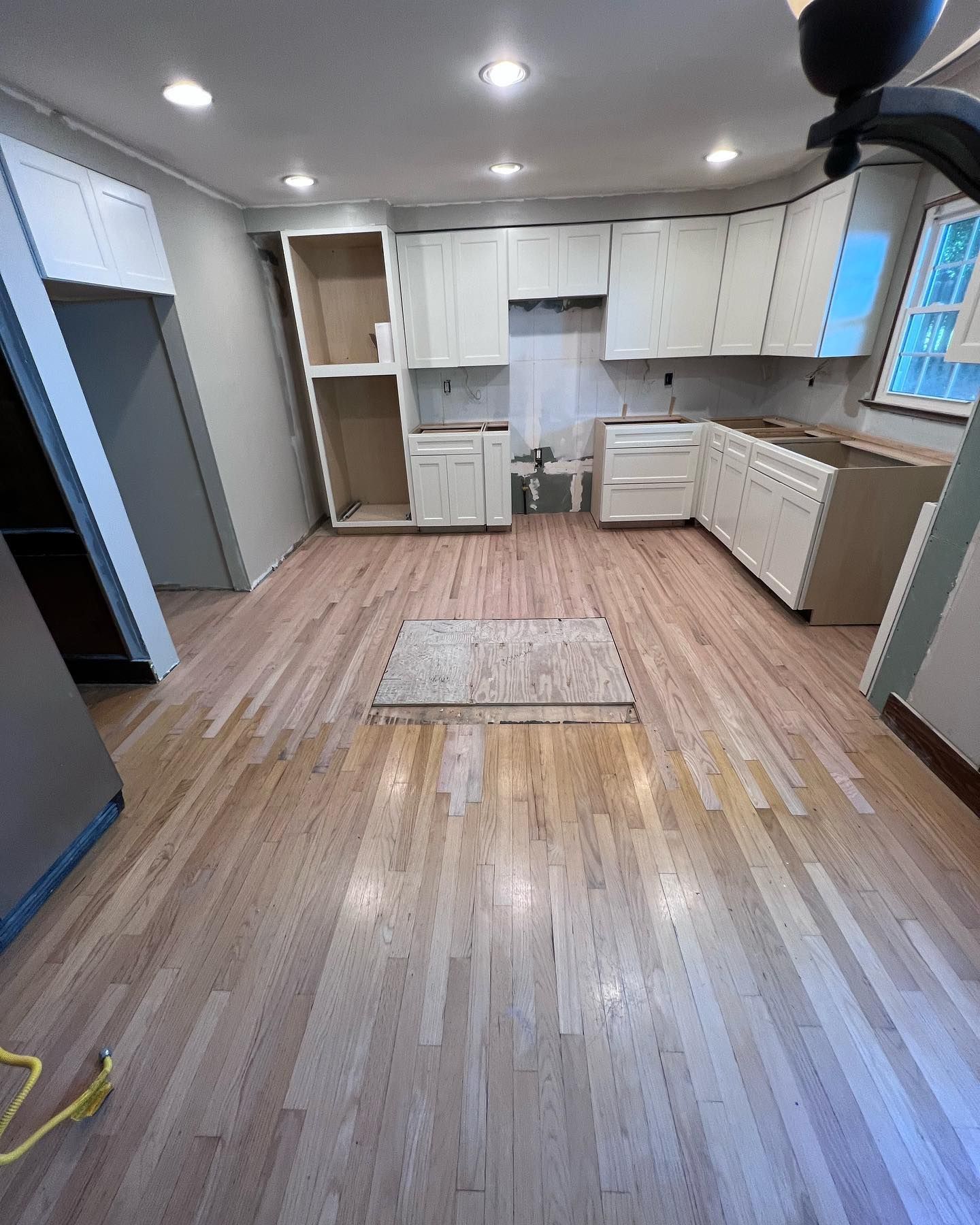 A kitchen with a tiled floor and a refrigerator.