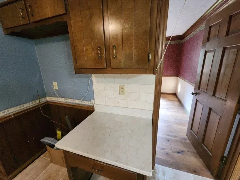 A kitchen with wooden cabinets and a white counter top.