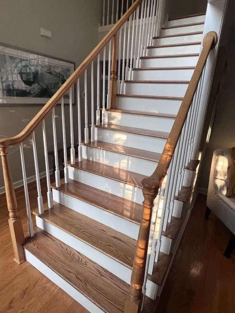 A staircase with wooden steps and white railings in a living room.