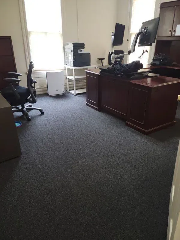 A room with a desk , chairs , computer and printer.