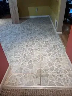 A tiled floor in a room with stairs leading up to it.