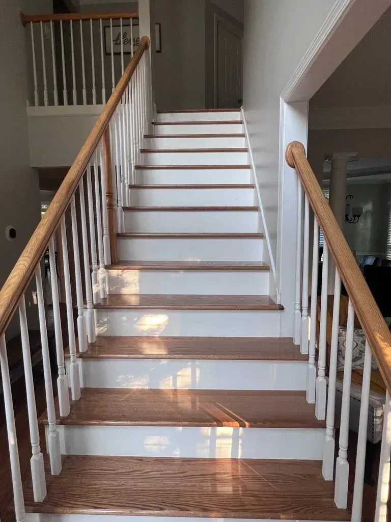 A set of wooden stairs with white railings in a house