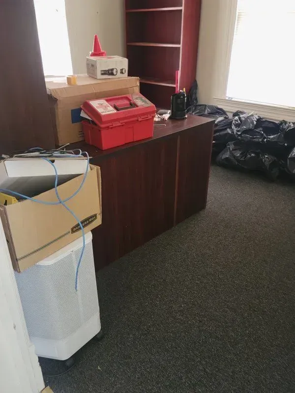 A room filled with boxes and a red box on top of a desk