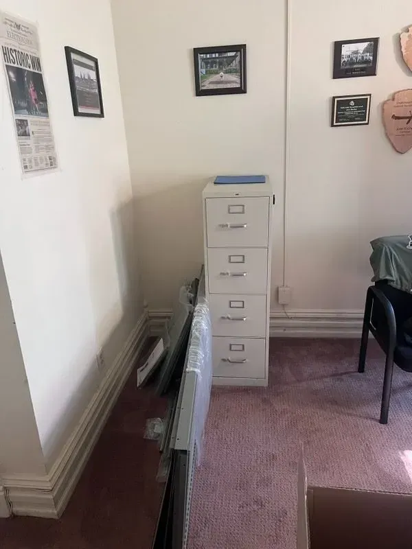 A room with a filing cabinet and pictures on the wall