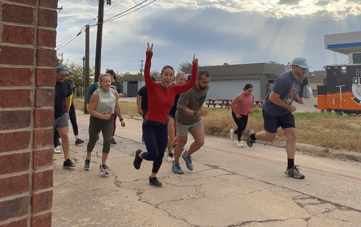Woman and man in a gym using battle ropes for exercise. They are intense, focused, and working out.